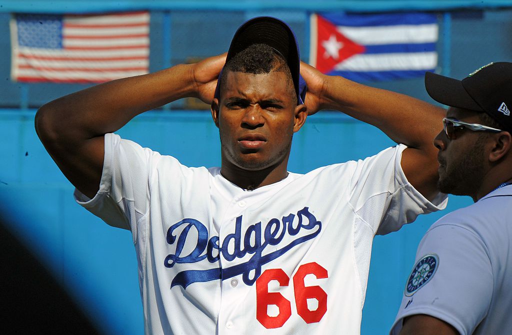 Cuban MLB player Yasiel Puig gestures during a children baseball training session at the Latin American Stadium in Havana, on December 16, 2015. Cuban baseball stars Jose Abreu and Yasiel Puig returned home Tuesday for the first time since defecting to join the American big leagues, part of an unprecedented Major League Baseball tour made possible by the thaw in US-Cuban relations. The delegation also includes Cuban-born player Alexei Ramirez, a free agent who left Cuba legally by marrying a Dominican in 2007. / AFP / YAMIL LAGE (Photo credit should read YAMIL LAGE/AFP/Getty Images)