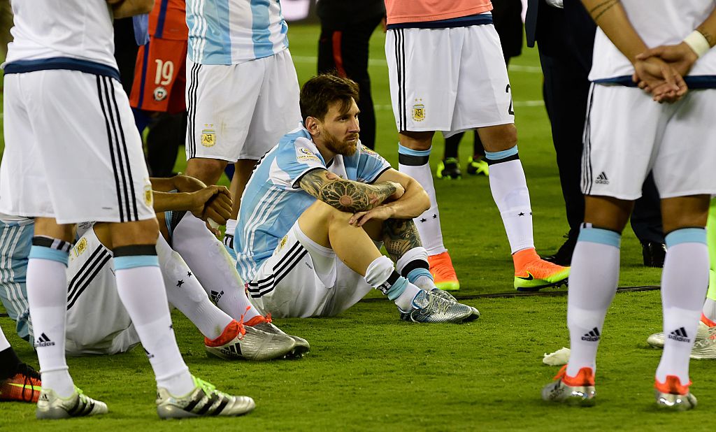 Argentina's Lionel Messi sits on the ground in dejection after being defeated by Chile in the penalty shoot-out of the Copa America Centenario final in East Rutherford, New Jersey, United States, on June 26, 2016. / AFP / ALFREDO ESTRELLA (Photo credit should read ALFREDO ESTRELLA/AFP/Getty Images)