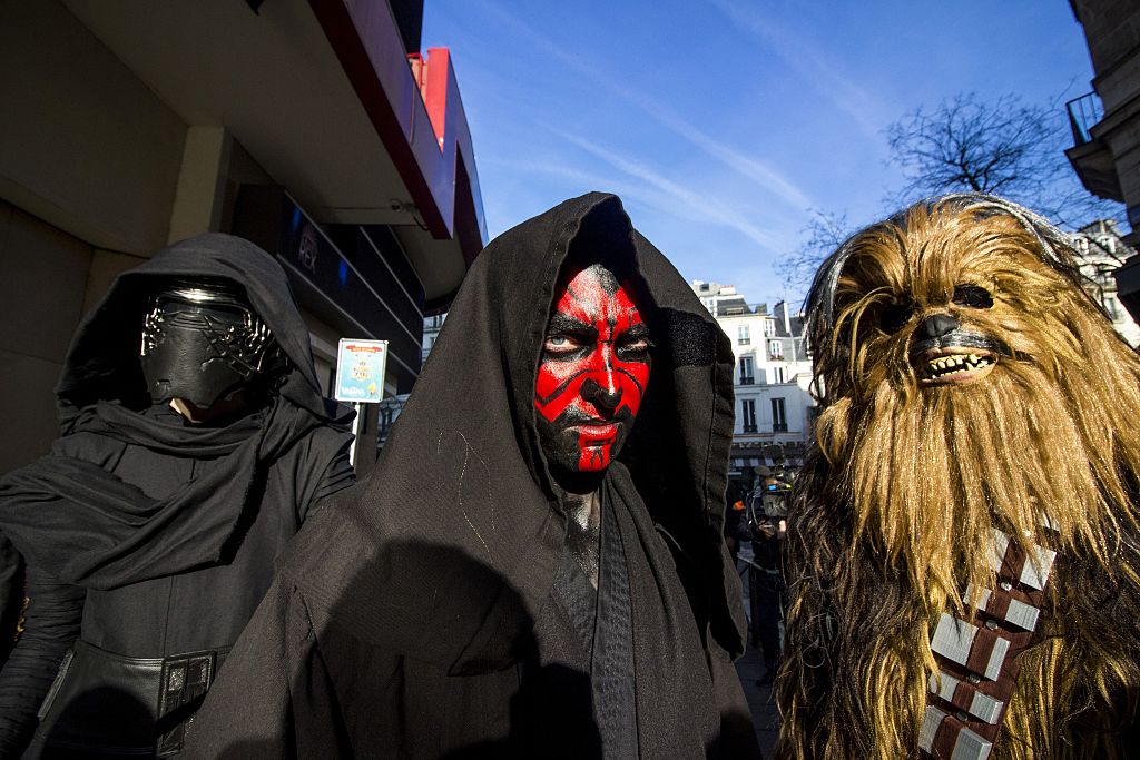 (From L) Three persons dressed as Kylo Ren, Dark Maul and Chewbacca of Star Wars pose on December 14, 2016 at the Grand Rex cinema in Paris on the first day of the European release of Star Wars Rogue One. Thousands of fans finally got to see the new Star Wars spin-off film on December 14, 2016 as it opened across Europe, dividing critics. "Rogue One: A Star Wars Story" has already notched up the highest first day pre-sales ever in the United States following last year's record-breaking "The Force Awakens".  / AFP / -        (Photo credit should read -/AFP/Getty Images)