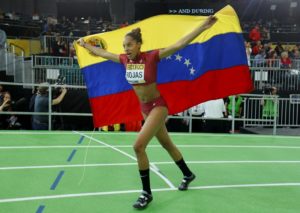 Yulimar Rojas of Venezuela celebrates with her country's flag after winning the gold medal in the women's triple jump during the IAAF World Indoor Athletics Championships in Portland, Oregon March 19, 2016.  REUTERS/Mike Blake
