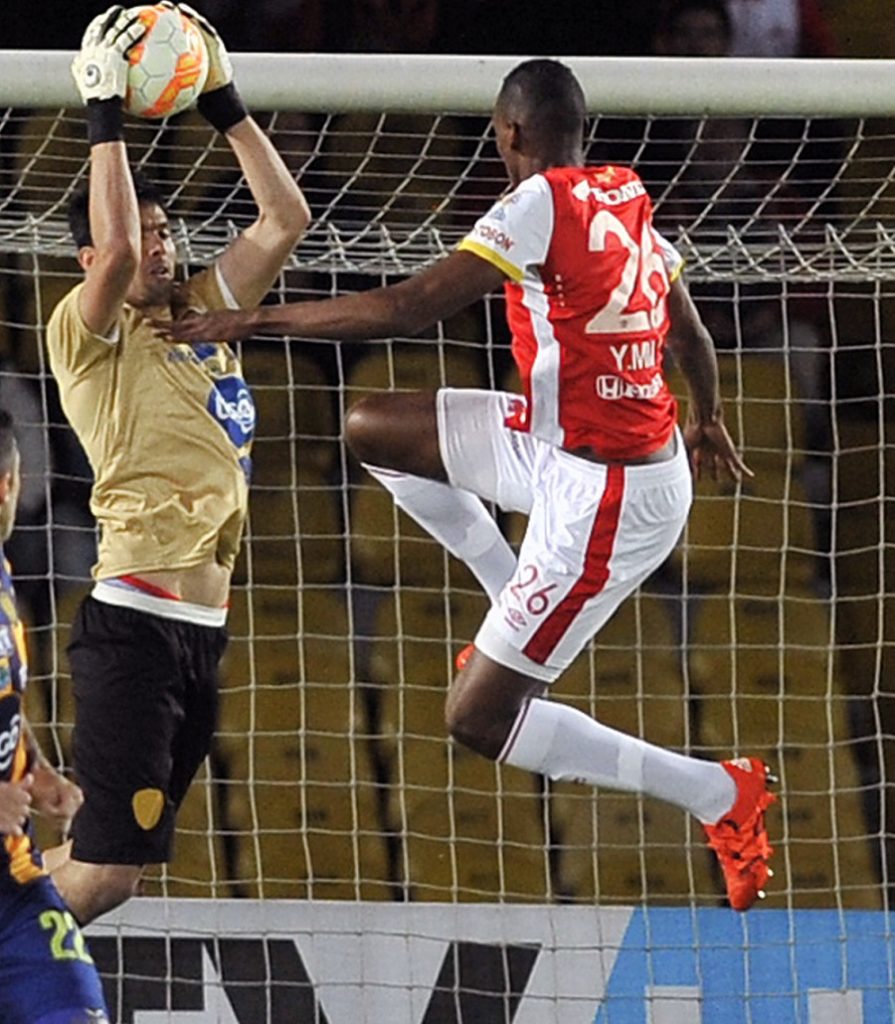 Yerry Mina (R) of Colombia's Santa Fe vies for the ball with goalkeeper Arnaldo Gimenez of Paraguay's Sportivo Luqueno during their Sudamericana Cup semifinal football match, at the Nemesio Camacho "El Campin" stadium, in Bogota, on November 25, 2015. AFP PHOTO/Guillermo Legaria / AFP PHOTO / GUILLERMO LEGARIA